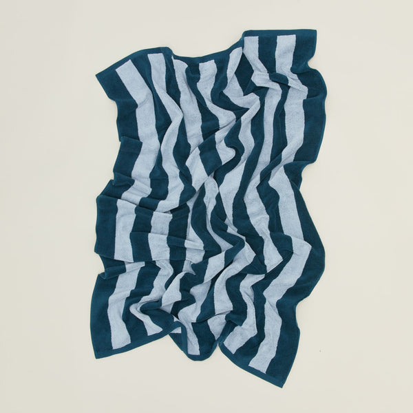 An overhead of a striped sky and peacock terry bath towel.